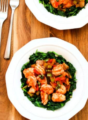 Mediterranean Shrimp with Spinach shown on serving plates with forks.