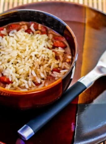 Square image for Slow Cooker Red Beans and Rice in serving bowl, on plate with spoon.