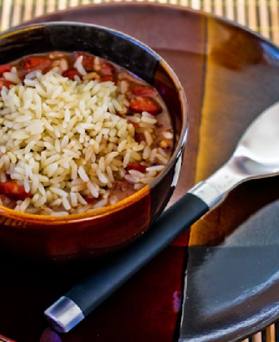 Slow Cooker Red Beans and Rice shown in serving bowl on plate with spoon