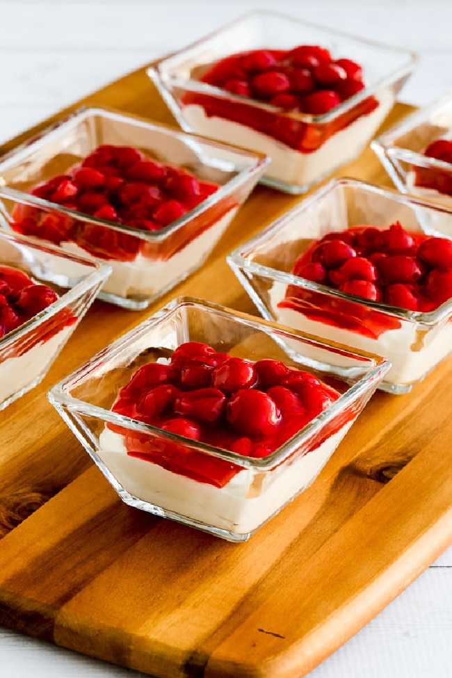 Low-Carb No Bake Cherry Cheesecake Dessert shown in serving dishes on cutting board