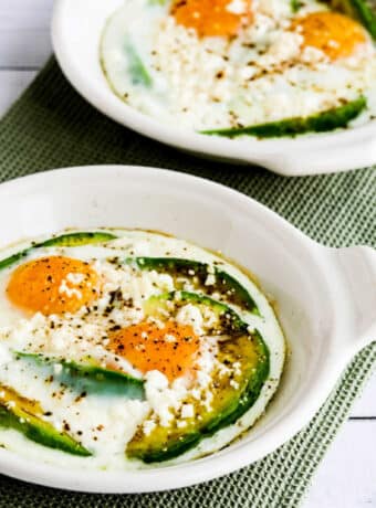 Square image of Baked Eggs with Avocado and Feta shown in individual baking dishes.