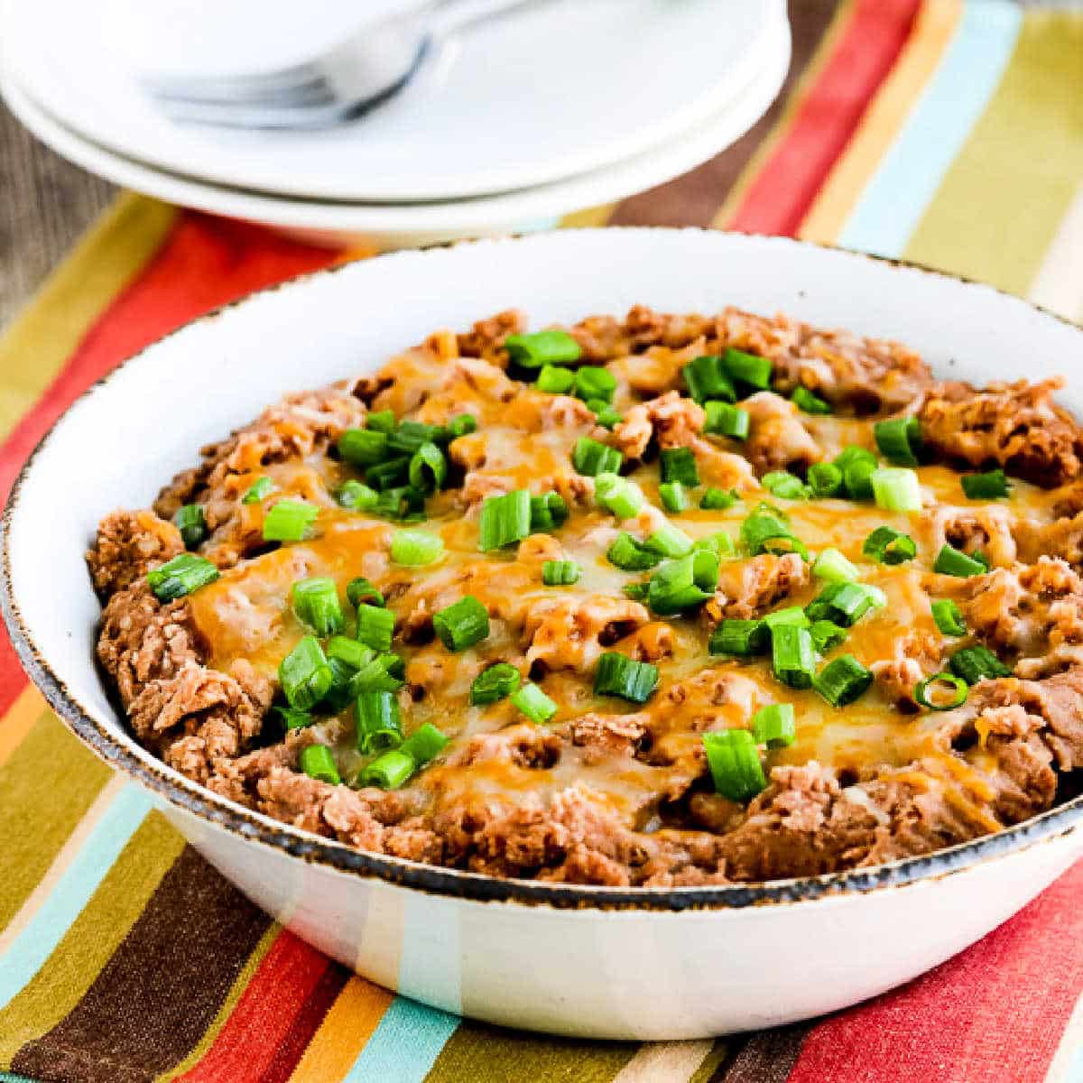 Square image of Instant Pot Refried Beans shown in serving bowl.