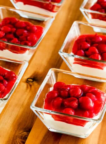 Square image for Low-Carb No Bake Cherry Cheesecake Dessert shown in individual square serving dishes.
