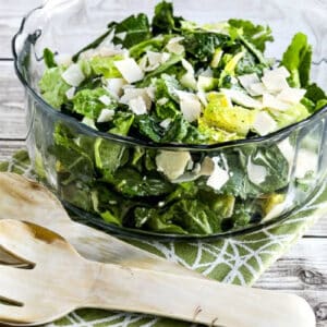 Caesar Salad with Kale, Romaine, and Shaved Parmesan shown in glass serving bowl with forks