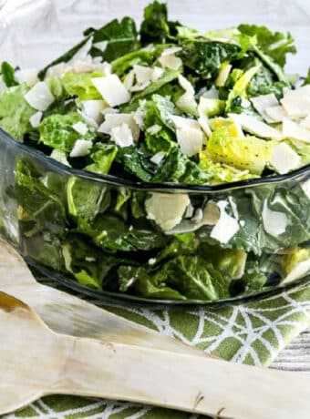 Caesar Salad with Kale, Romaine, and Shaved Parmesan shown in glass serving bowl with forks