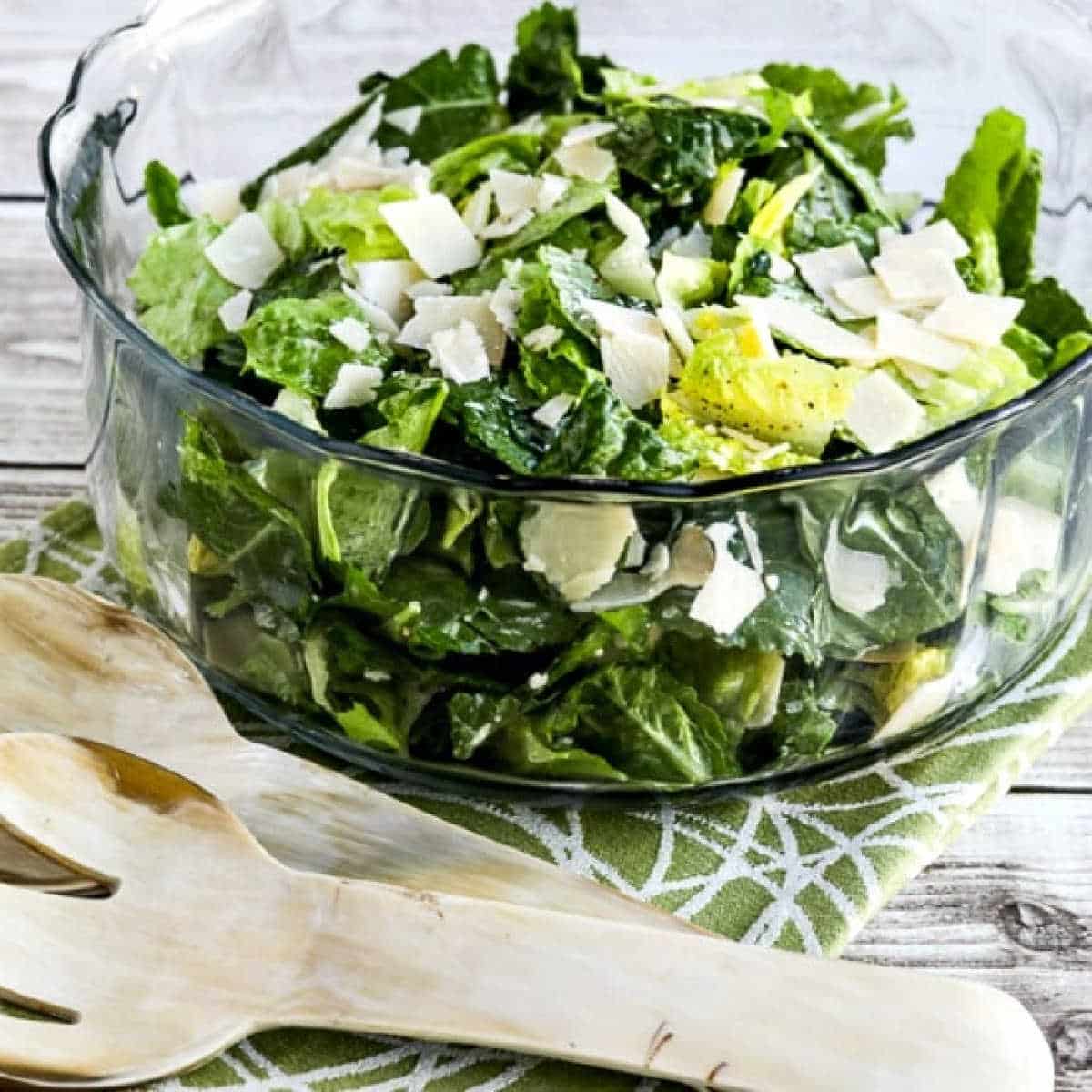 Caesar Salad with Kale, Romaine, and Shaved Parmesan shown in glass serving bowl with forks