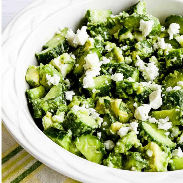 Cucumber Salad with Avocado and Feta shown in serving bowl on green-yellow napkin