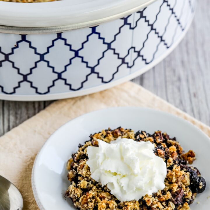 Slow Cooker Blueberry Crisp one serving on plate with slow cooker in back