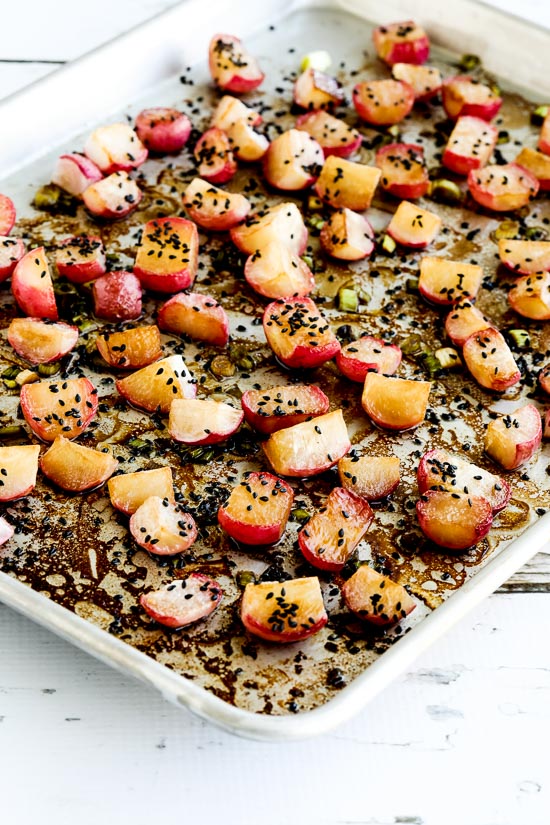 Roasted Radishes shown on baking sheet with sesame seeds