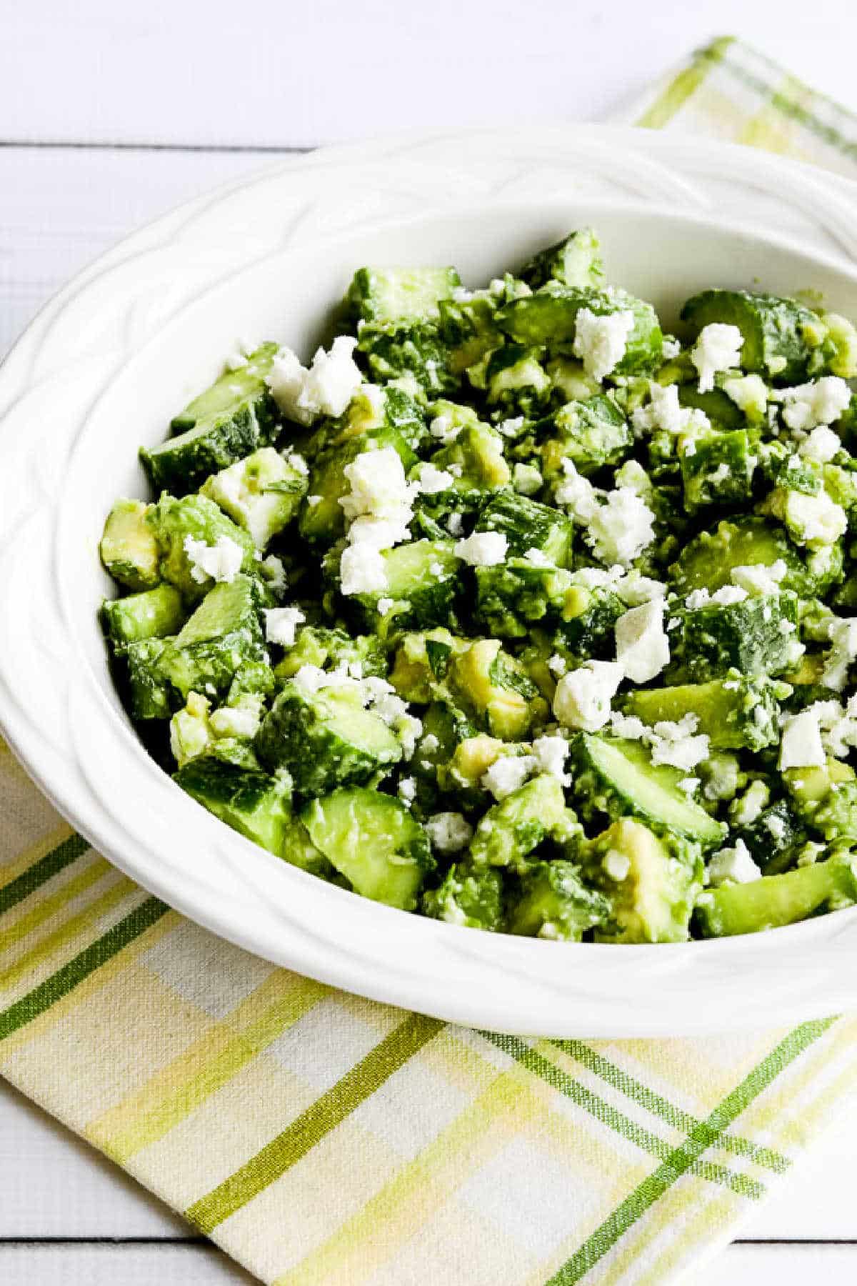 Cucumber salad with avocado and feta shown in a serving bowl
