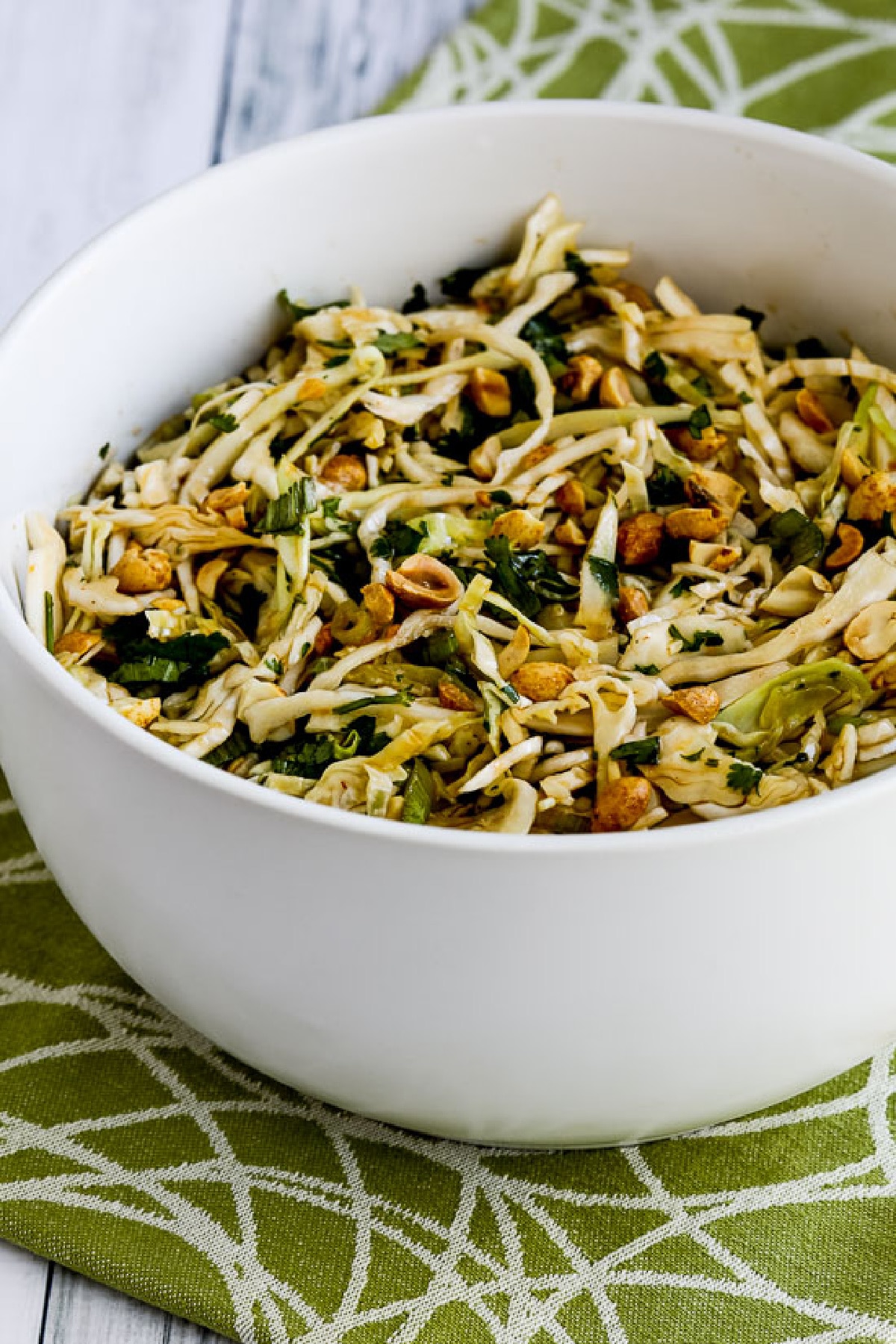 Spicy Cilantro-Peanut Slaw in serving bowl on green-white napkin