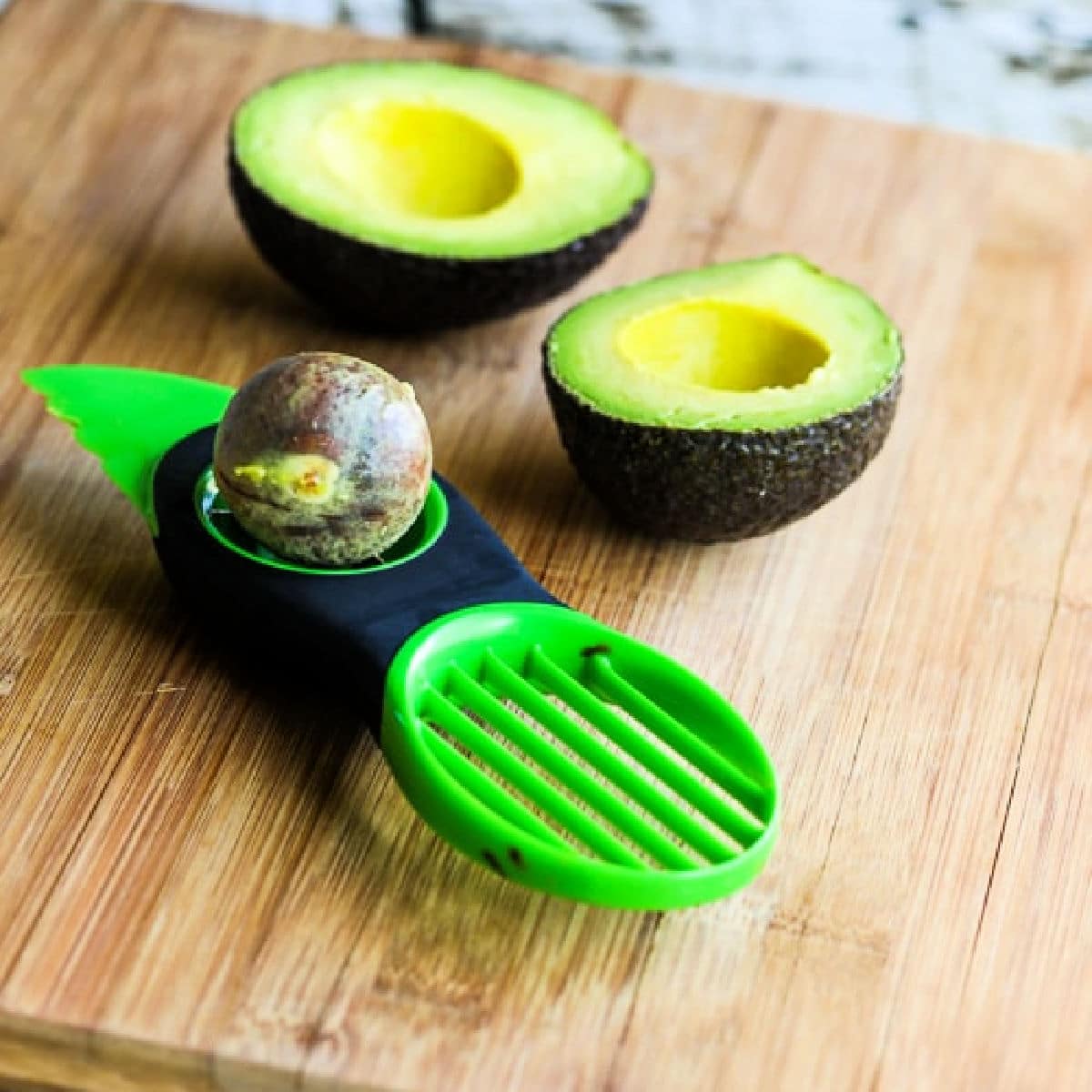 OXO Good Grips Avocado Tool shown on cutting board with avocado.