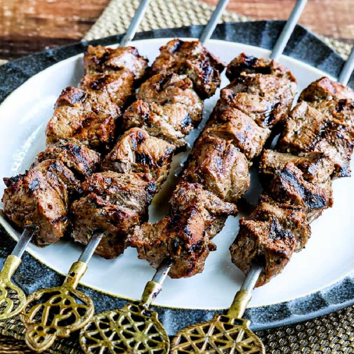 Marinated Beef Kabobs shown on serving plate with decorative skewers.