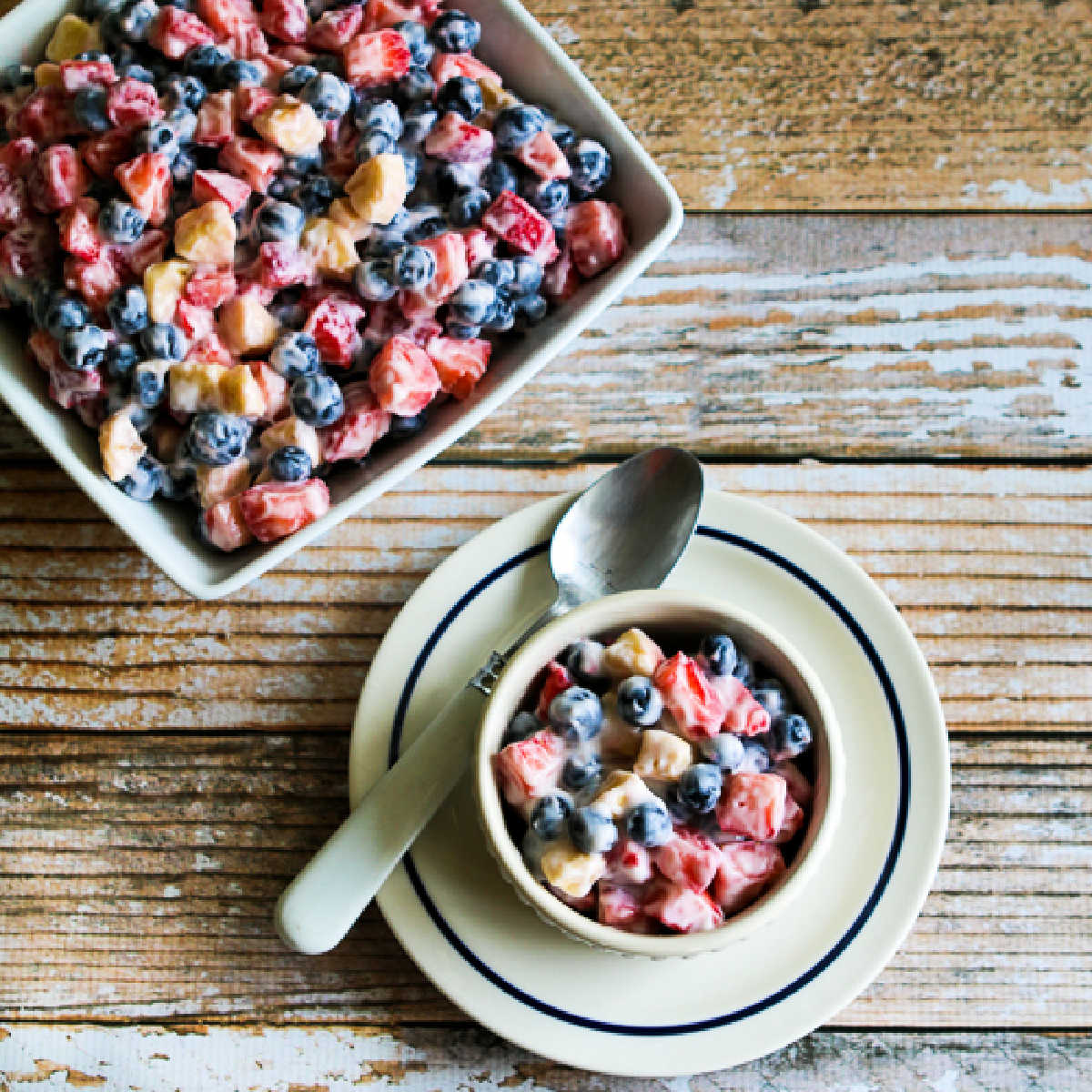 Square image of Red White and Blue Salad in serving bowl and one serving in front.