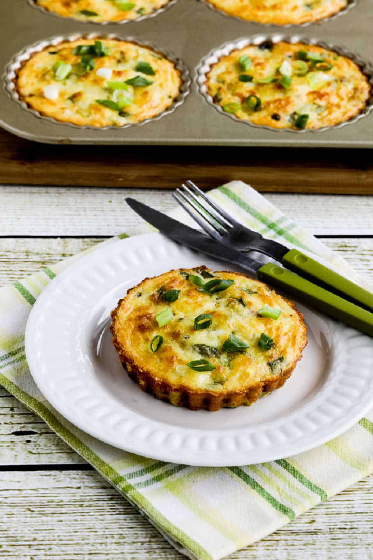Zucchini breakfast tart shown on serving plate with tart in background, away