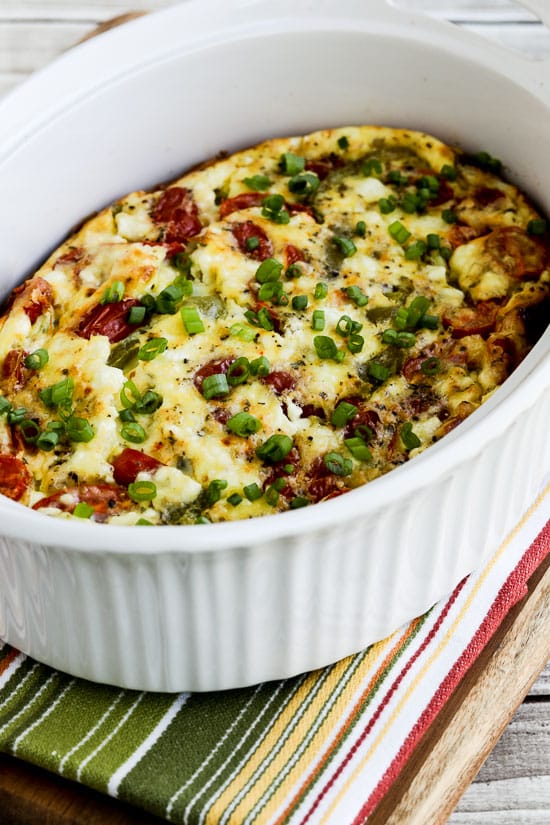 Roasted Green Pepper and Tomato Breakfast Casserole shown in baking dish on striped napkin