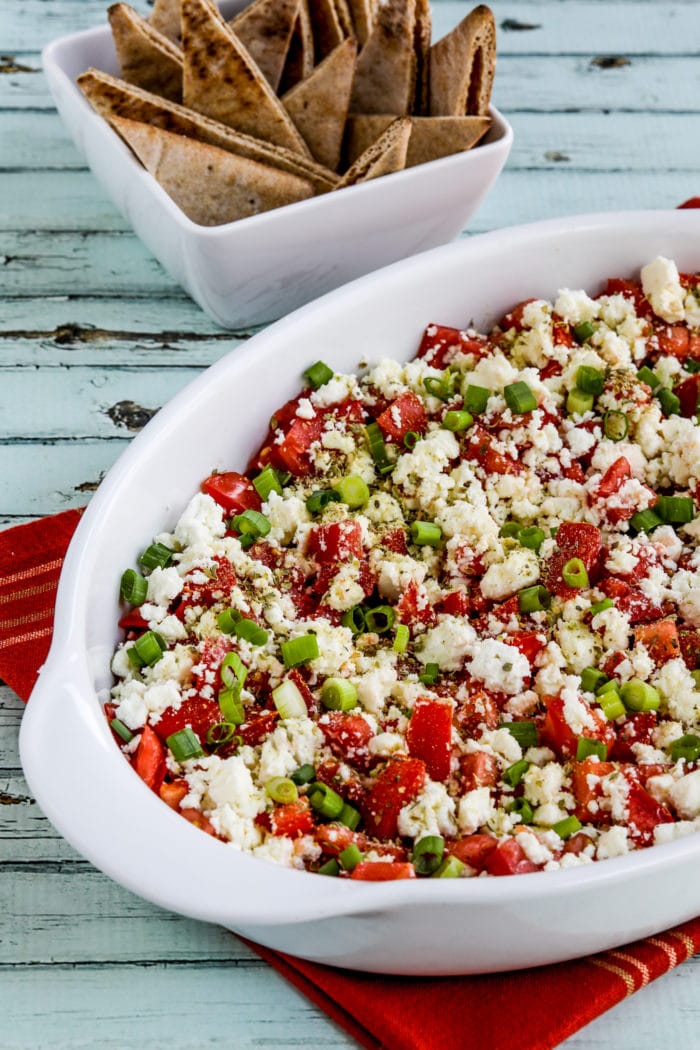 Greek Dip with Tomatoes and Feta finished dip in serving dish with pita in background