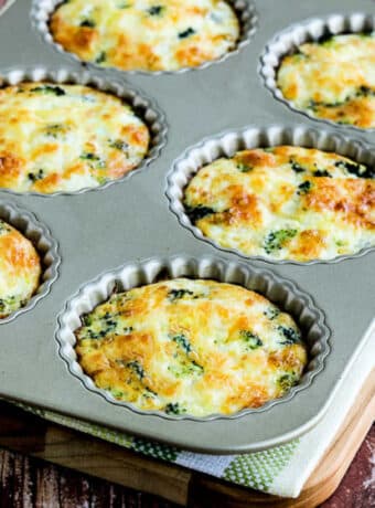 Square image of Mini Frittatas with Broccoli and Three Cheeses in tart pan.