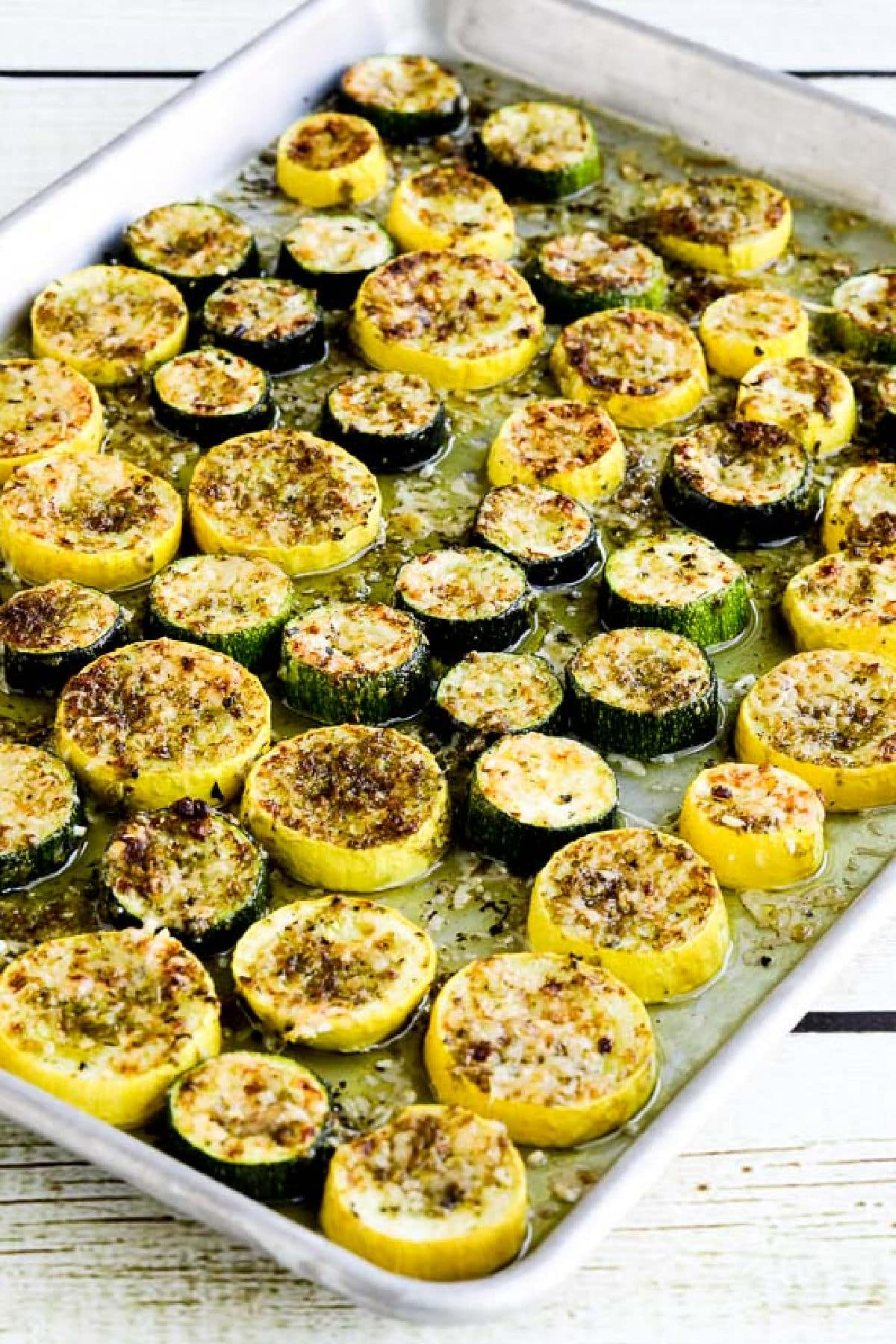 Summer squash with pesto and parmesan displayed on the baking tray