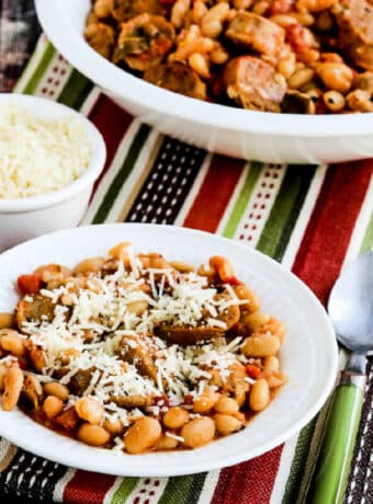 Square image for Italian Sausage and White Beans with Sage showing beans in serving bowl with one serving dish in front.