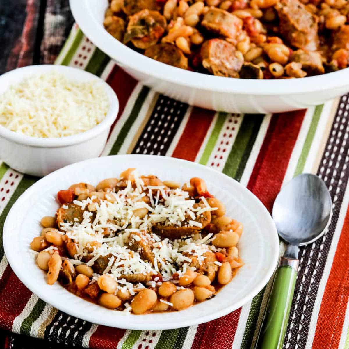 Square image for Italian Sausage and White Beans with Sage showing beans in serving bowl with one serving dish in front.