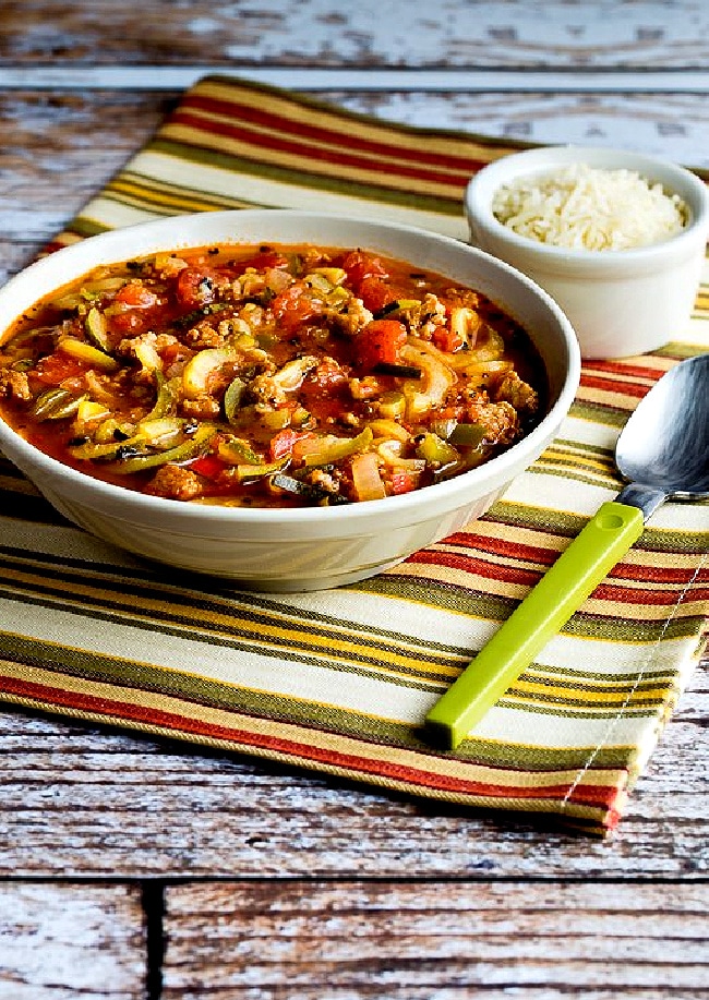 Italian Sausage Soup with Tomatoes and Zucchini Noodles photo of bowl of soup with Parmesan