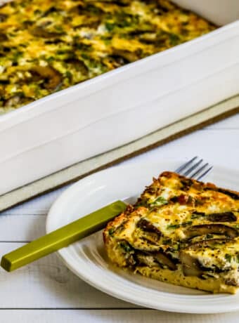 Square featured image for Mushroom and Feta Breakfast Casserole showing one serving in front and casserole dish in back.