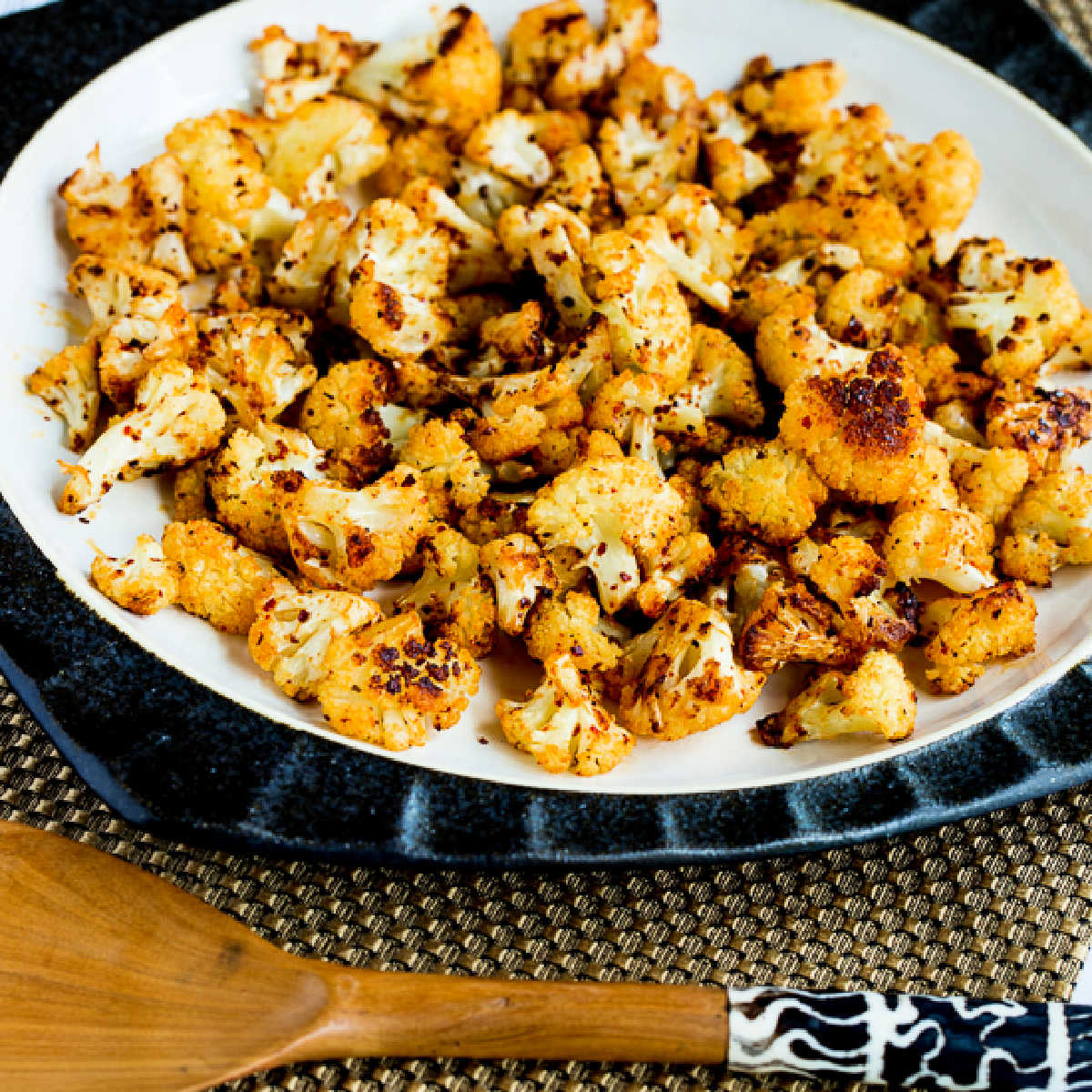Square image for Roasted Spicy Cauliflower shown on serving plate with decorative serving spoon.