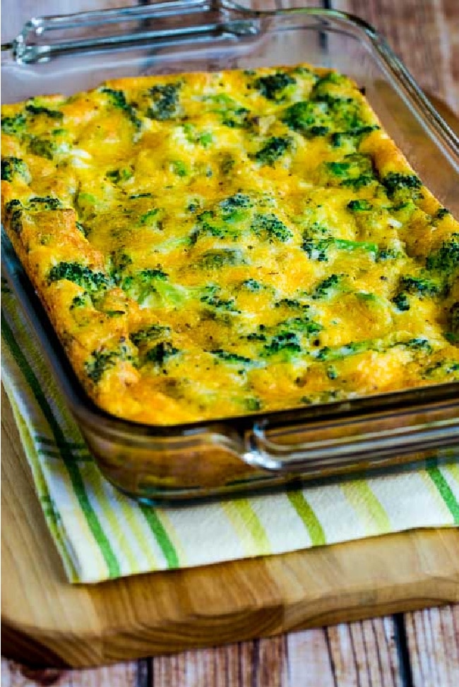 Broccoli Cheese Breakfast Casserole in baking dish shown on napkin and cutting board