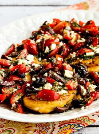 Greek Chicken with Tomato, Olive, and Feta Topping square image of chicken on serving platter