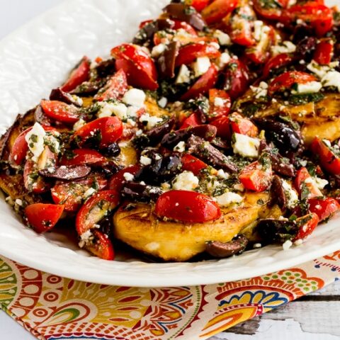 Greek Chicken with tomatoes, olives, and Feta shown on serving plate