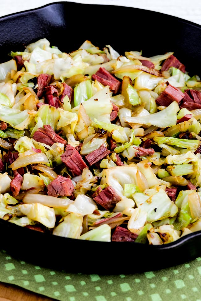 Fried cabbage with corned beef shown in cast iron skillet