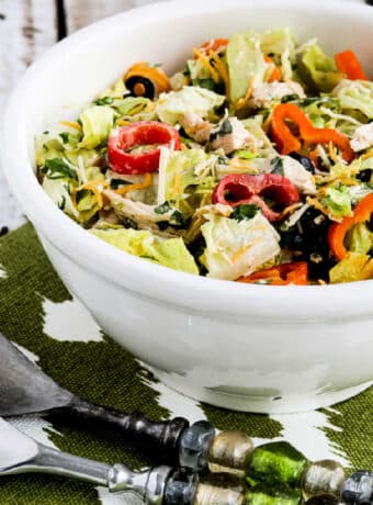 Square image of Southwest Chicken Salad shown in serving bowl with large spoons.