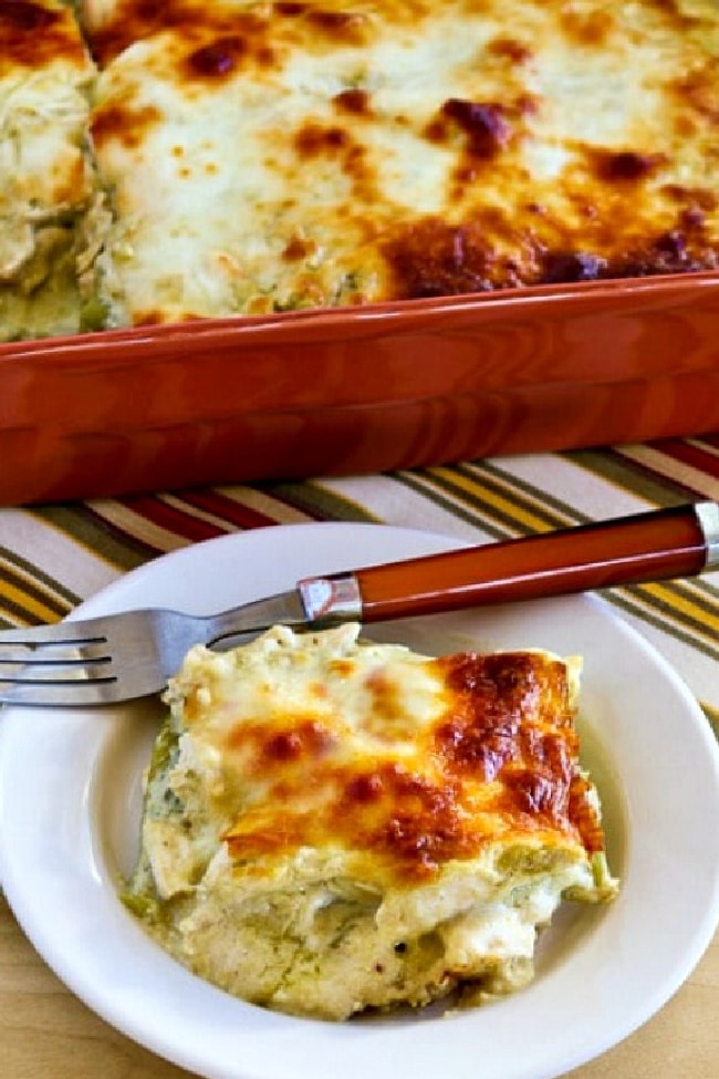 Green Chile and Chicken Mock Enchilada Casserole with one serving on plate and baking dish in back.