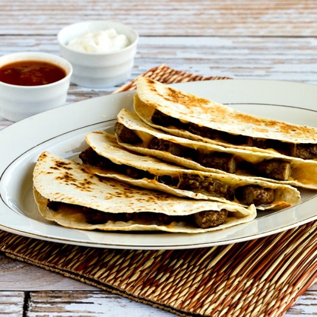Sausage and Cheese Breakfast Quesadillas square thumbnail photo of tortillas on plate with salsa and sour cream on the side.
