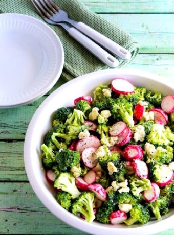 Broccoli and Radish Salad with Gorgonzola finished salad in serving bowl with plates and forks in background