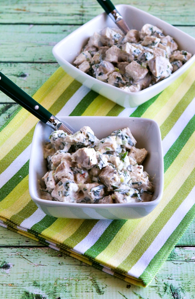 Chicken Salad with Basil in two serving bowls with forks and napkin