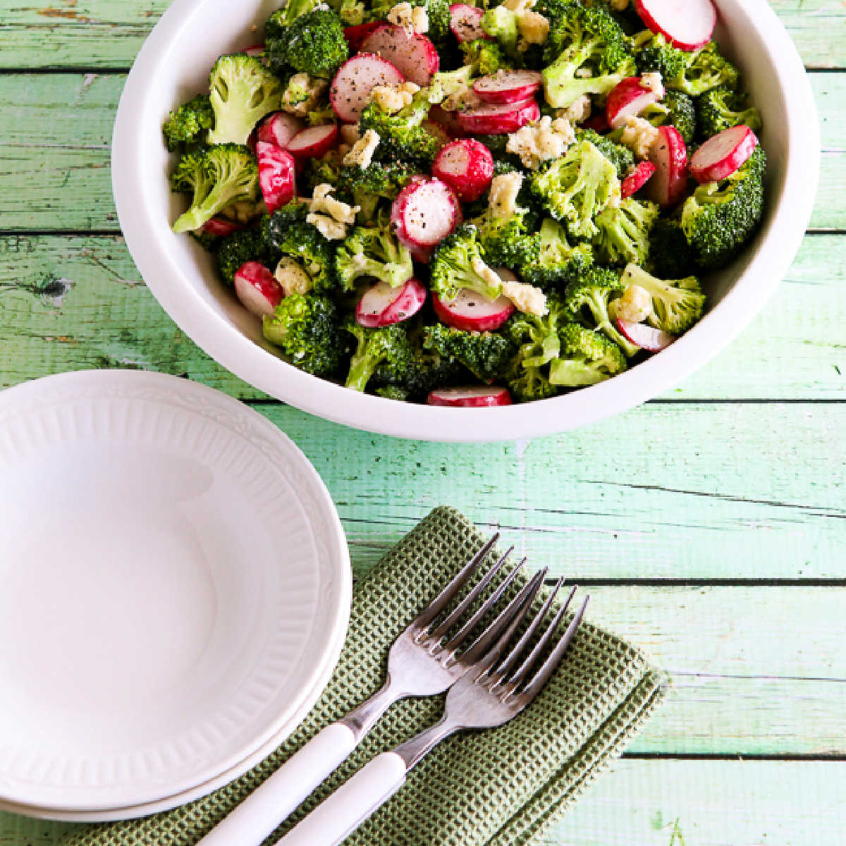 Blue Cheese Broccoli Radish Salad in bowl with plates and forks