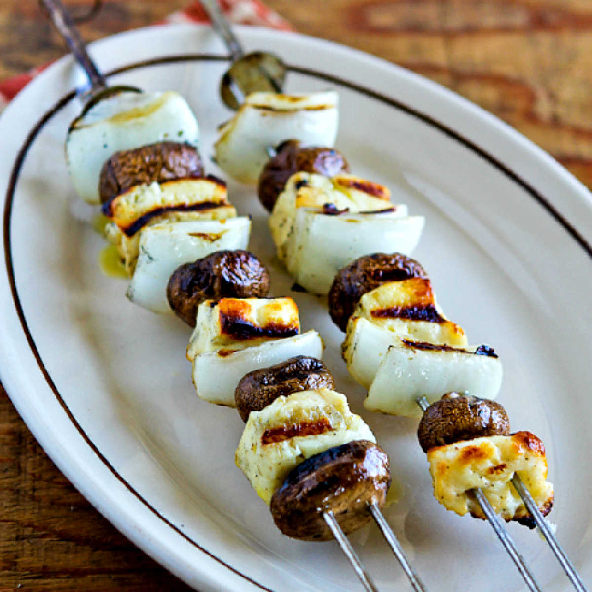 Square image of grilled halloumi cheese and mushrooms served on a platter