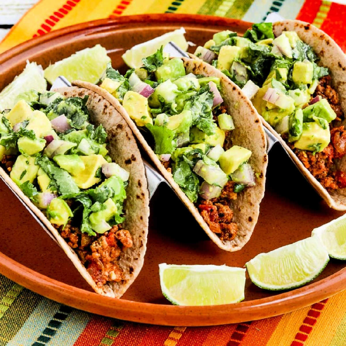 Square image for Turkey Tacos with Avocado Salsa shown on serving platter with limes.