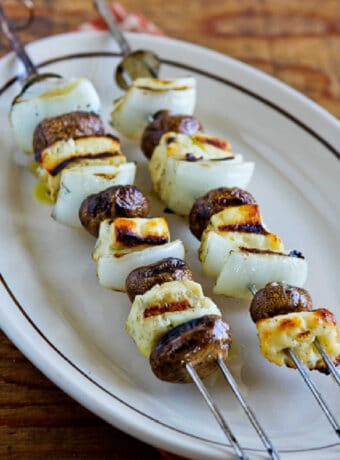 Grilled Halloumi Cheese with Mushrooms shown on serving plate on wooden table