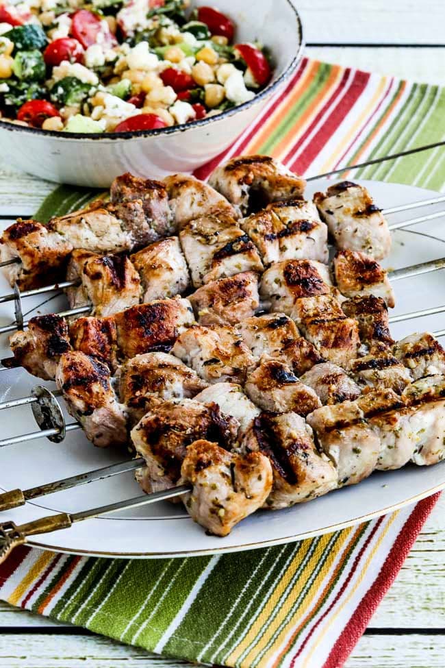 Souvlaki on serving platter on striped napkin.