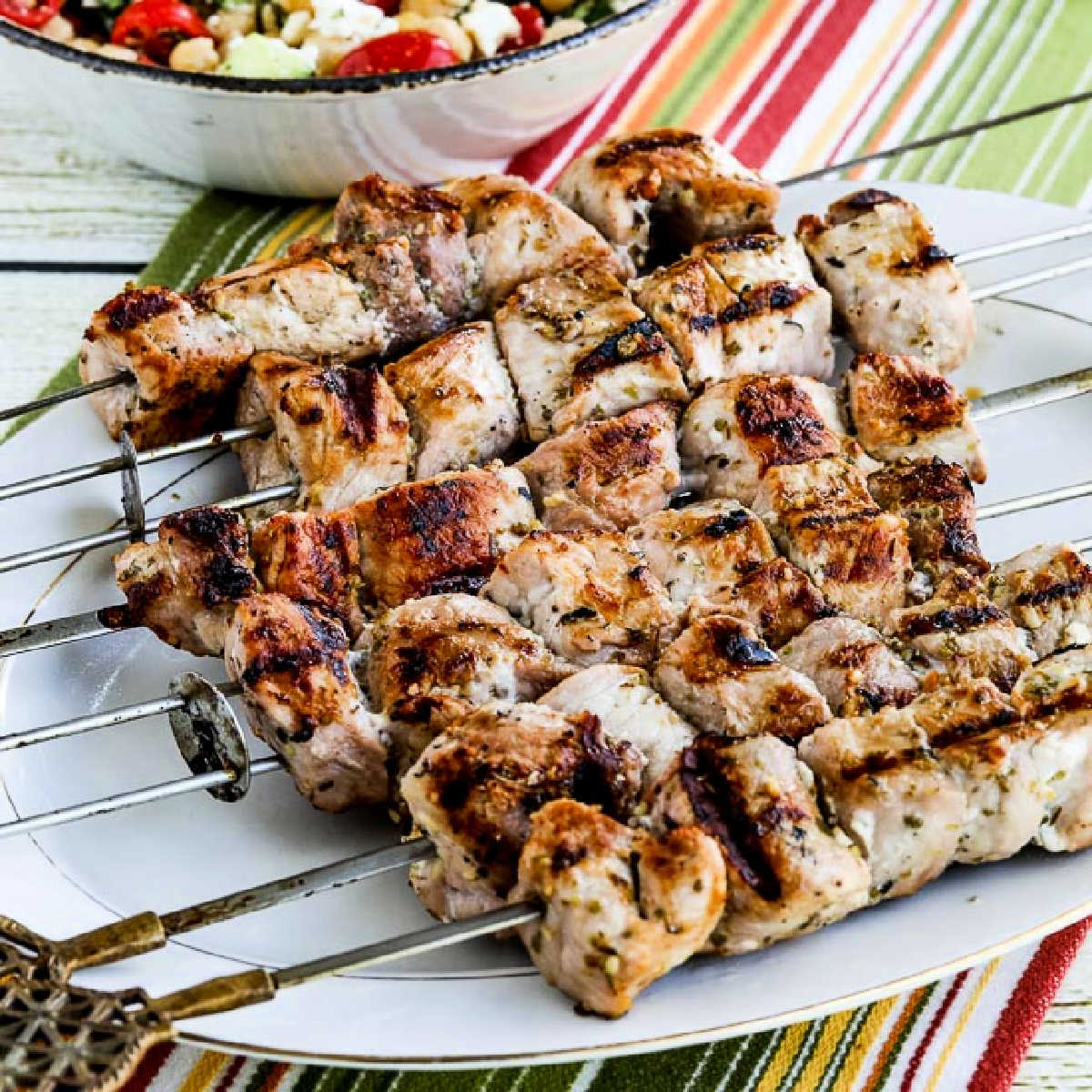 Pork Souvlaki Recipe showing pork on skewers on serving platter.