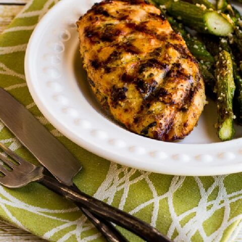 Rosemary Mustard Grilled Chicken on serving plate with asparagus, with fork, knife, and napkin