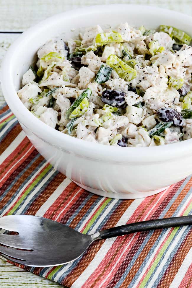 Greek Chicken Salad with Peperoncini shown in serving bowl with fork and napking