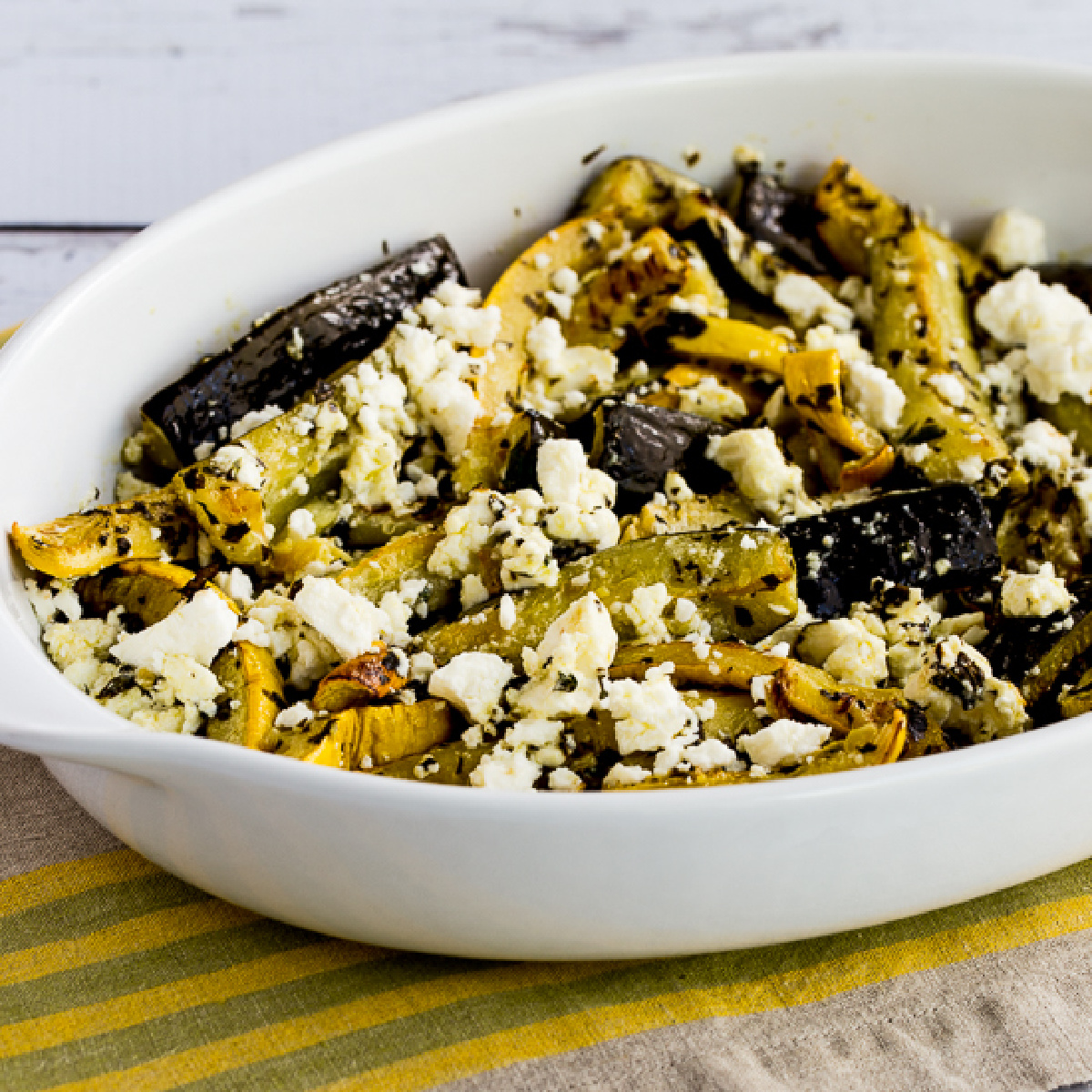 square photo of Baked Summer Squash with Lemon, Mint, and Feta in serving dish