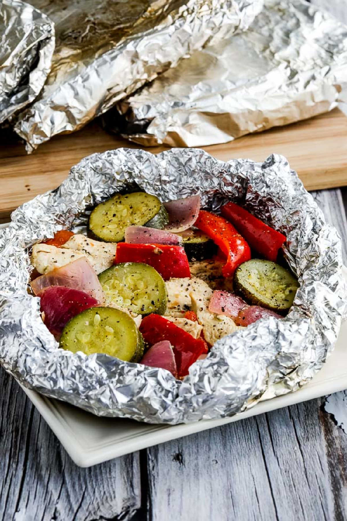 Low-Carb Foil Packet Dinner with foil folded back and wrapped dinners in background on cutting board