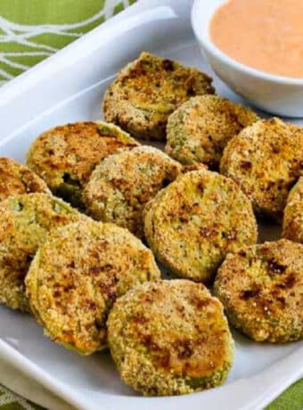 square image of Oven-Fried Green Tomatoes with Sriracha-Ranch Dipping Sauce on serving plate with sauce