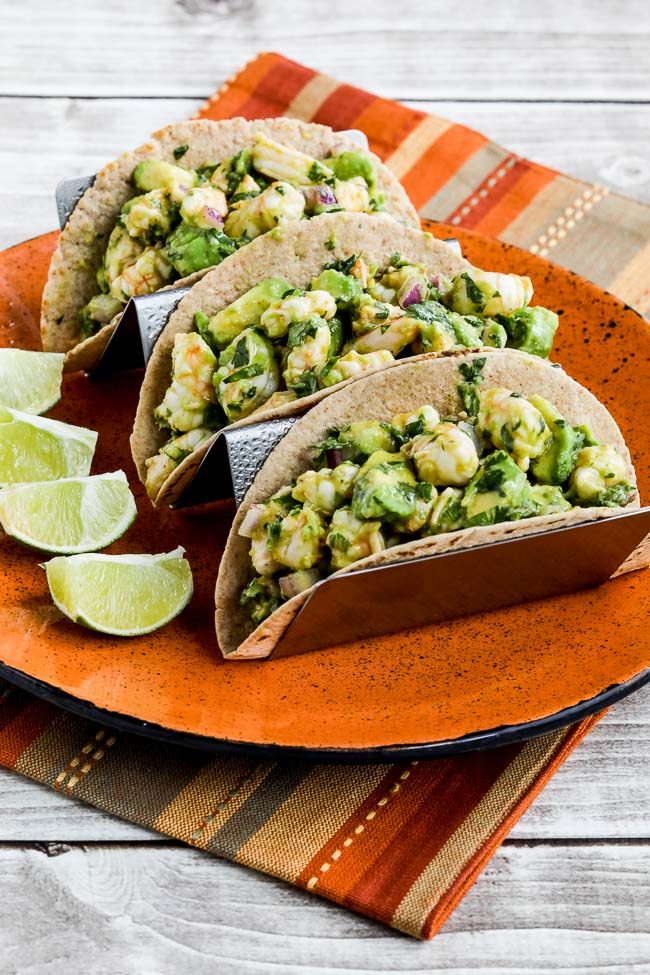 Shrimp Avocado Tacos shown with 3 tacos on serving plate with lime