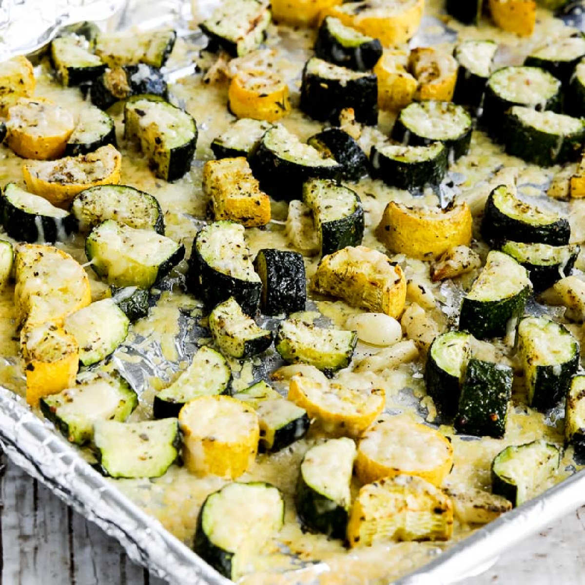 Square photo of roasted summer squash with garlic and parmesan on a baking sheet